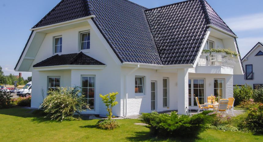 Ein modernes weißes Haus mit Balkon und Terrasse